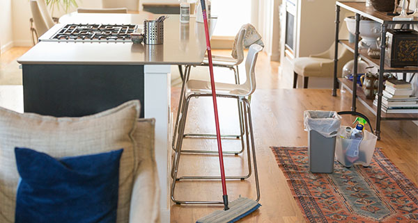 clean kitchen area with mop trash bin and cleaning supplies visible