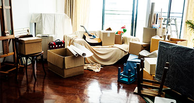 a cluttered room filled with moving boxes furniture and a guitar suggesting organization for eleven items